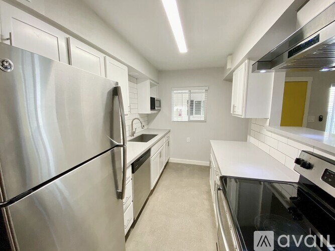 A modern kitchen with stainless steel appliances and white cabinetry.