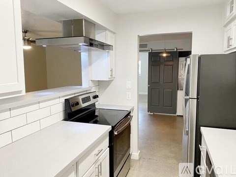 A kitchen with white cabinets and a black countertop.