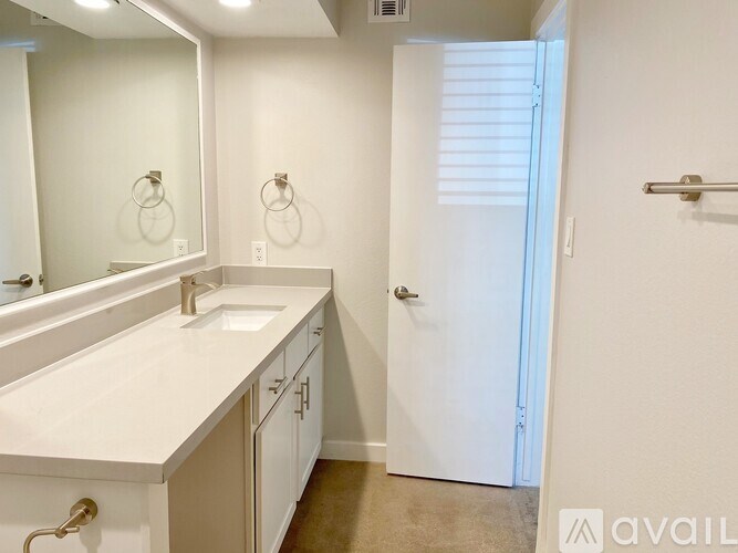 A bathroom with a sink, mirror, and a closed door.