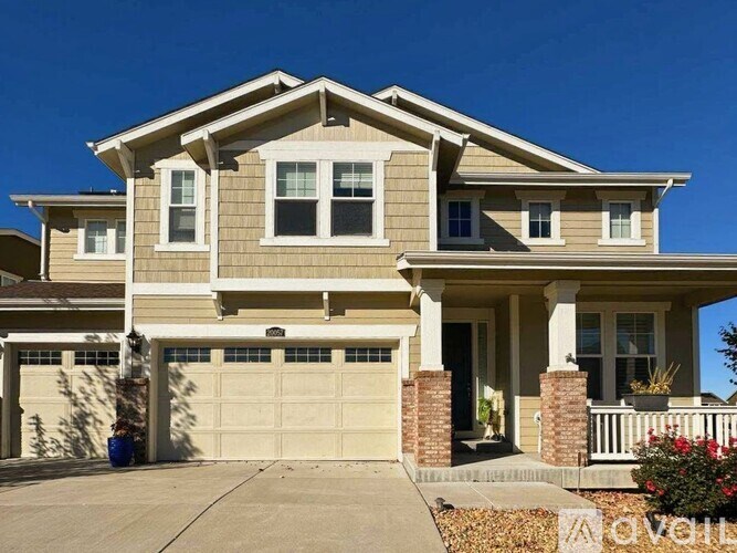 A two-story house with a garage and a front porch.