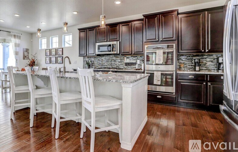 A kitchen with dark brown cabinets and white countertops.