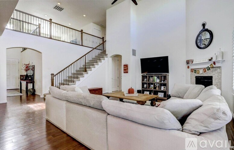 A living room with a white couch and a wooden coffee table.