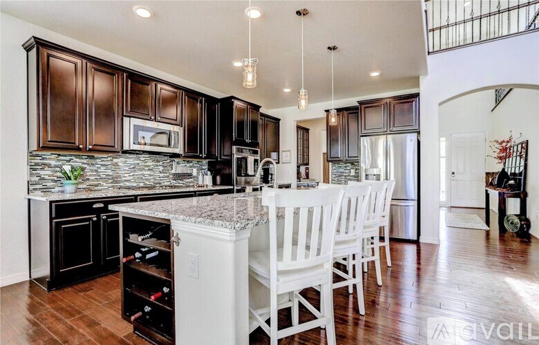 A kitchen with dark brown cabinets and a granite countertop.