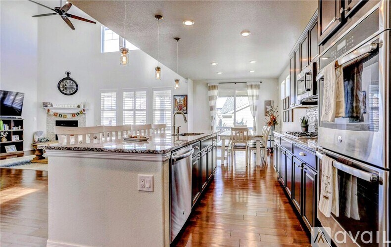 A modern kitchen with stainless steel appliances and wooden floors.