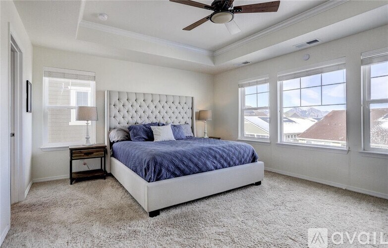 A bedroom with a large bed and a ceiling fan.