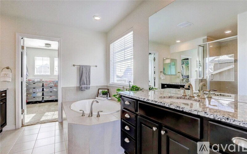 A bathroom with a large mirror, sink, and black cabinets.