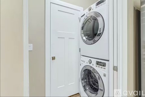A white washing machine is in a cabinet in a room.