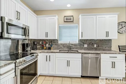 A kitchen with white cabinets and stainless steel appliances.