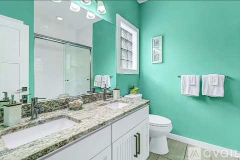 A bathroom with green walls and a marble countertop.