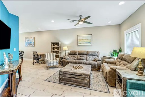 A living room with a brown leather couch and a wooden coffee table.