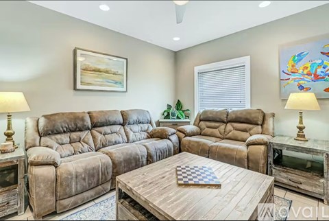 A living room with brown leather furniture and a wooden coffee table.