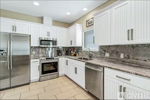 A kitchen with white cabinets and stainless steel appliances.
