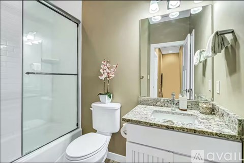 A bathroom with a marble countertop and a white toilet.