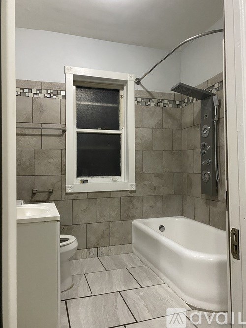 A white bathroom with a toilet, sink, and tub.