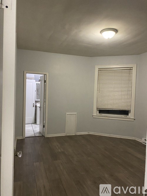 A room with a window and wooden flooring.