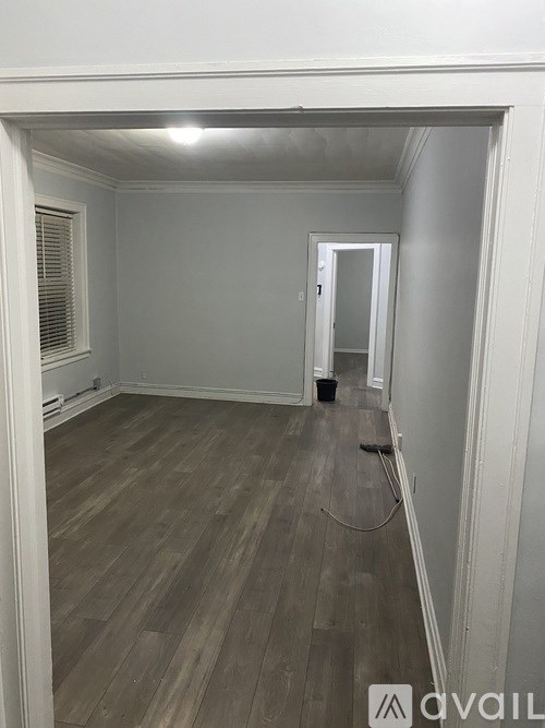 A room with wooden flooring and white walls.