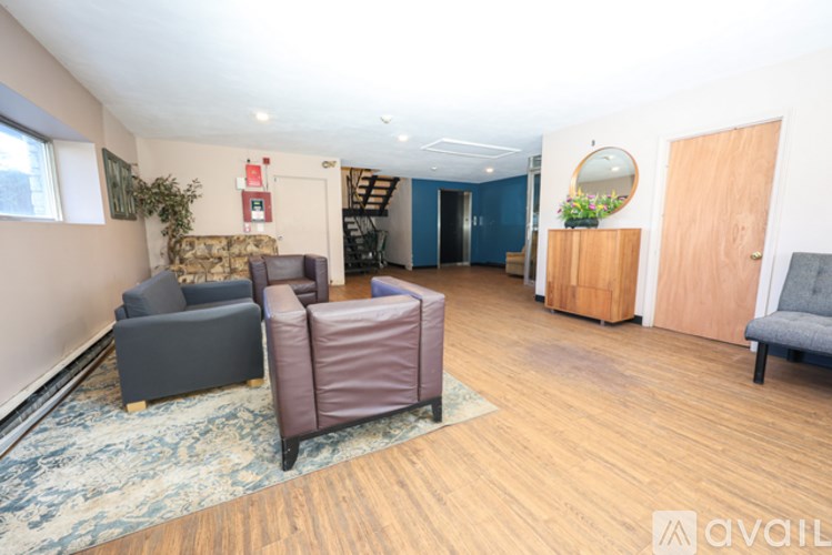 A living room with a grey couch, a brown armchair, and a blue sofa.
