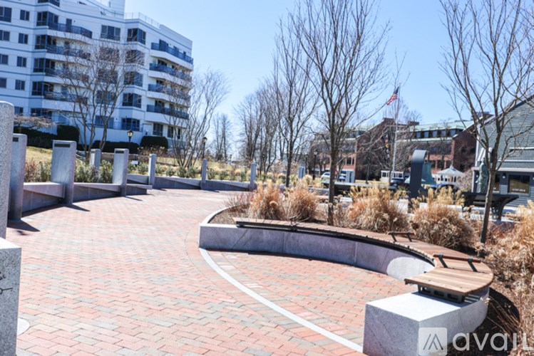 A brick walkway leads to a building with a flag on top.