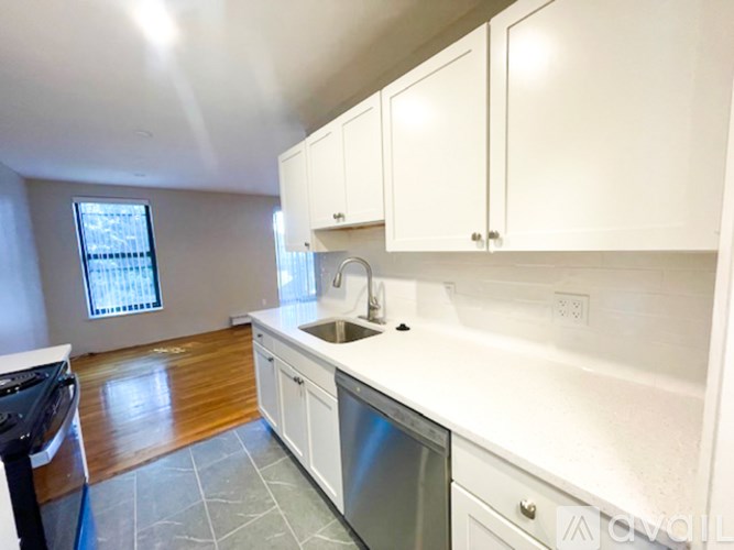 A kitchen with white cabinets and a stainless steel dishwasher.