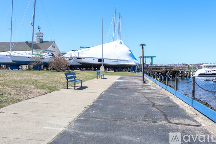 A walkway with benches and boats in the background.