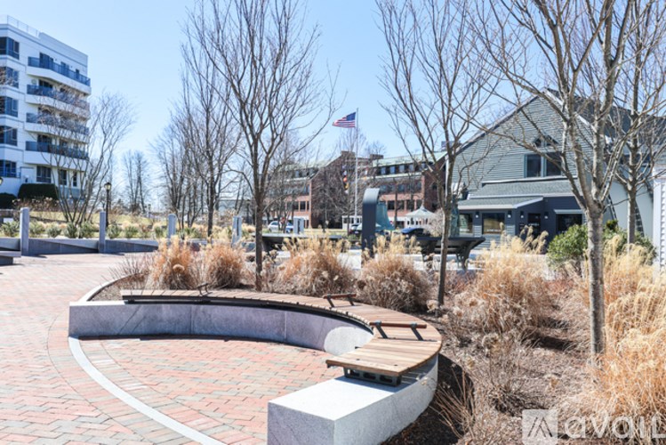 A park with a bench and a brick pathway.