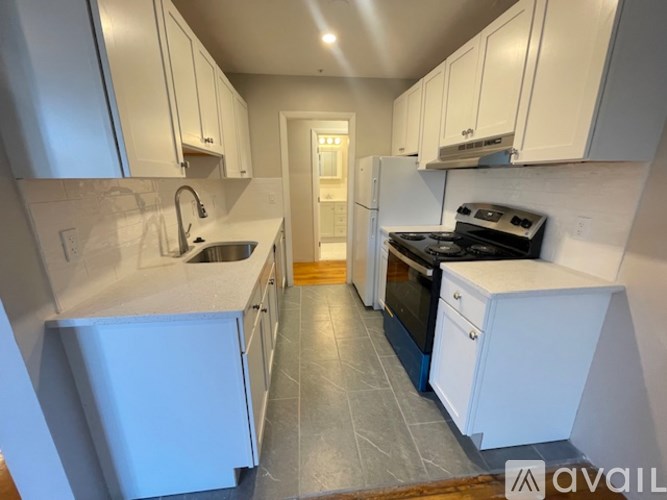 A kitchen with white cabinets and a black stove top oven.