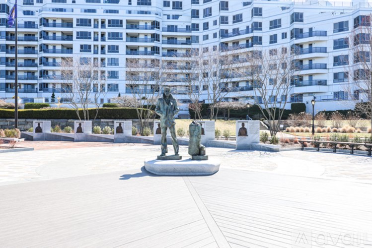 A statue in the middle of a courtyard with a building in the background.