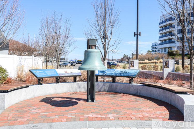 A large bell is in the center of a brick circle.