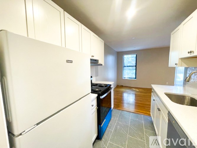 A kitchen with a white refrigerator, blue dishwasher, and white countertops.