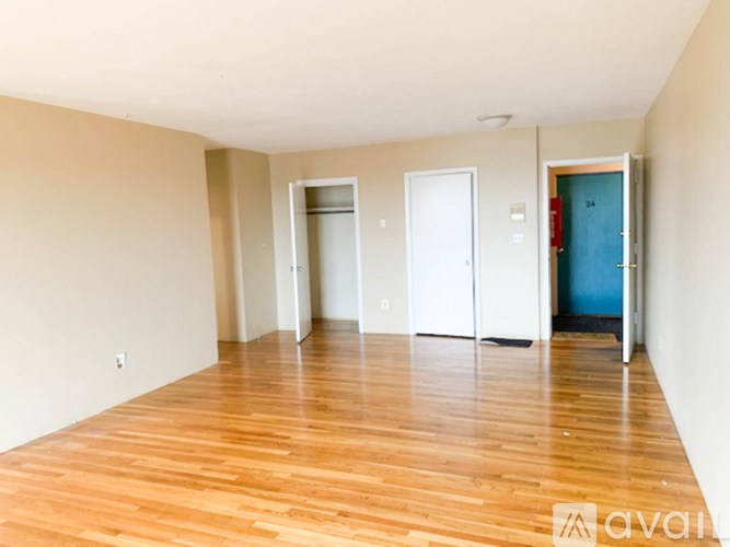 A room with wooden floors and three doors.