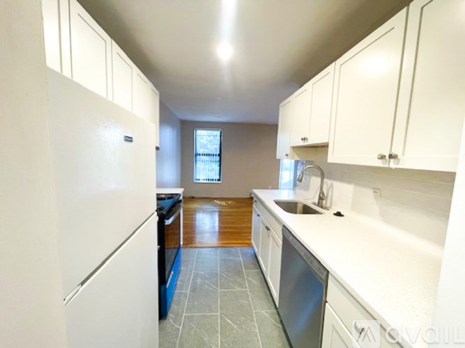 A kitchen with white cabinets and a blue dishwasher.