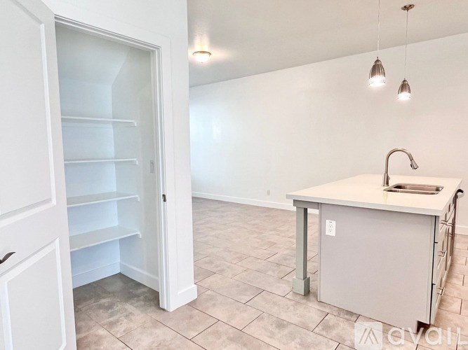 A kitchen area with a sink and a refrigerator with an open door.