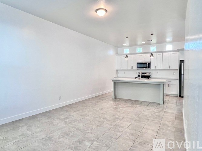 A spacious kitchen with white cabinets and a microwave.