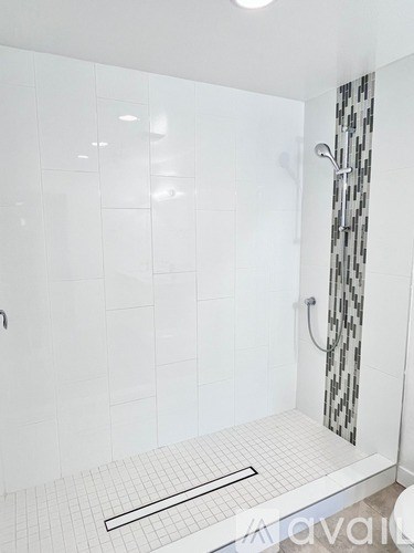 A white tiled bathroom with a walk in shower.