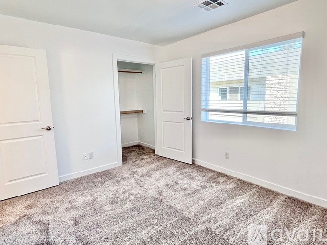 A carpeted room with a doorway leading to another room.