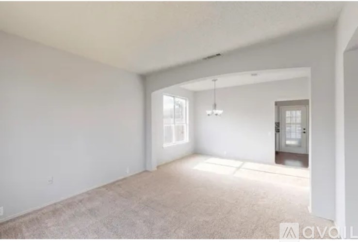 A spacious room with a door and a window.