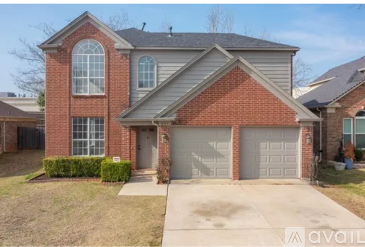A two-story house with a garage and a driveway.