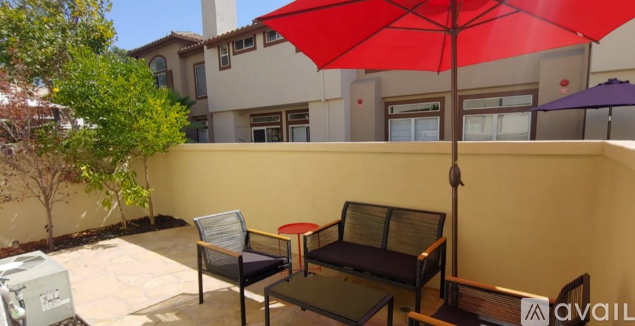 A red umbrella is on a table outside a building.
