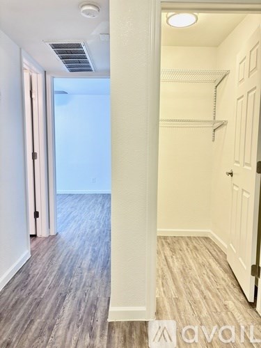 A hallway with a white door and a white wall.