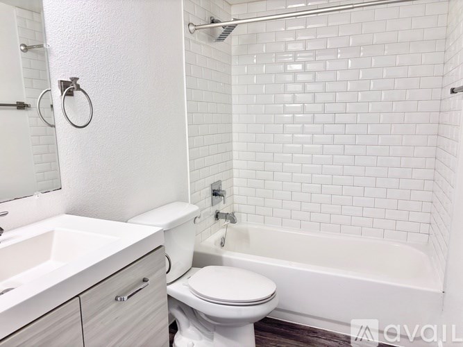 A white bathroom with a toilet, sink, and bathtub.