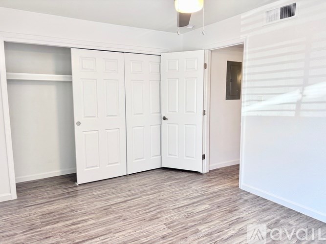 A room with white doors and a wooden floor.