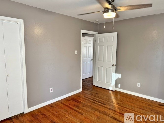 A room with a ceiling fan and two doors.