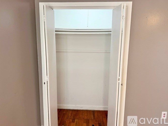 A white door is open to a room with a window.
