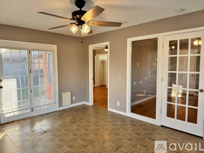 A room with a ceiling fan and tiled floor.