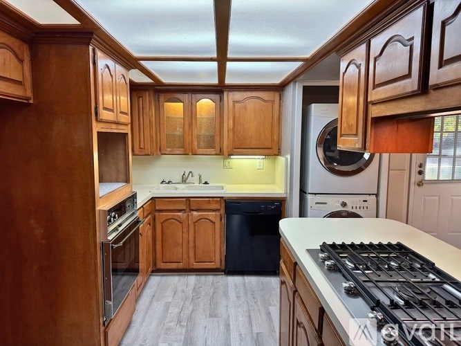 A kitchen with wooden cabinets and a black stove top.