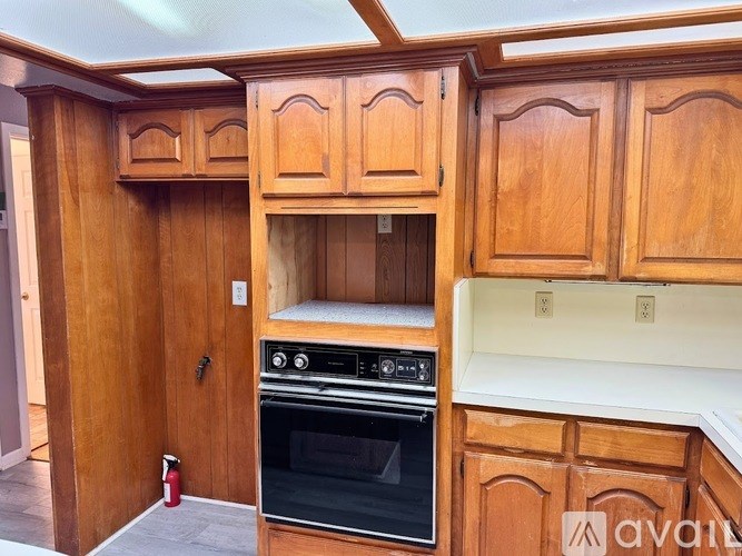 A kitchen with wooden cabinets and a stove top oven.