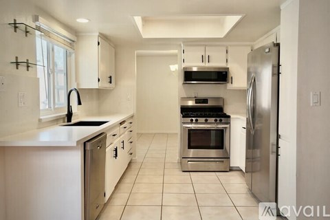 A kitchen with white cabinets and stainless steel appliances.
