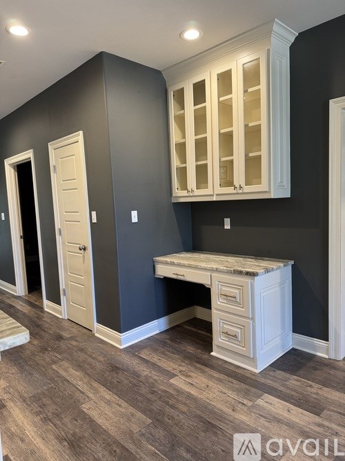 A room with a desk and a cabinet above it.