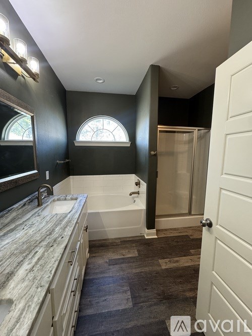 A bathroom with a marble countertop and a bathtub.