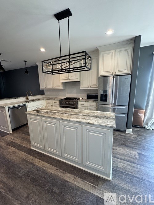 A kitchen with a marble countertop and a refrigerator.
